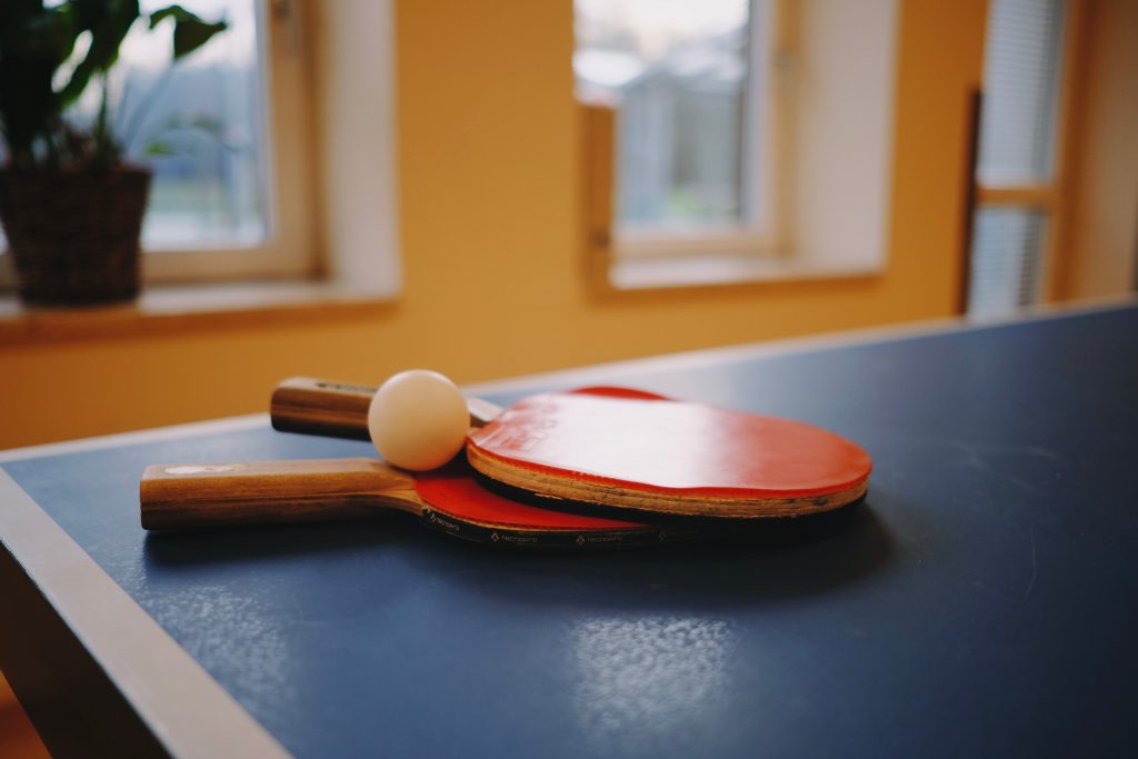 Två pingisrack och en pinigboll på ett pingisbord.
